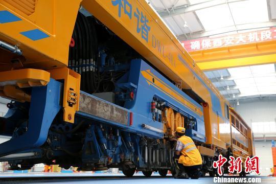 圖為工人正在清理大型養路機械?！堖h 攝